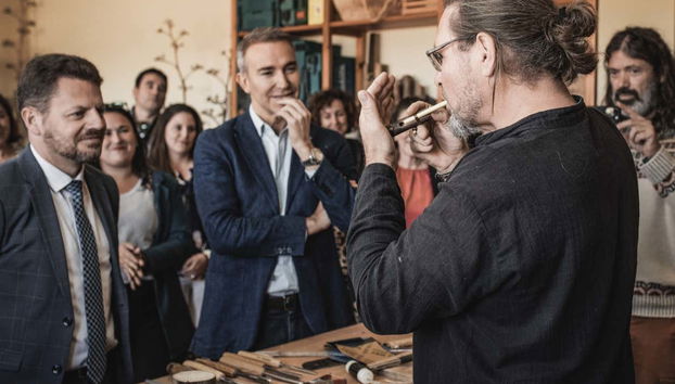 El artesano tocando un instrumento de madera de agave