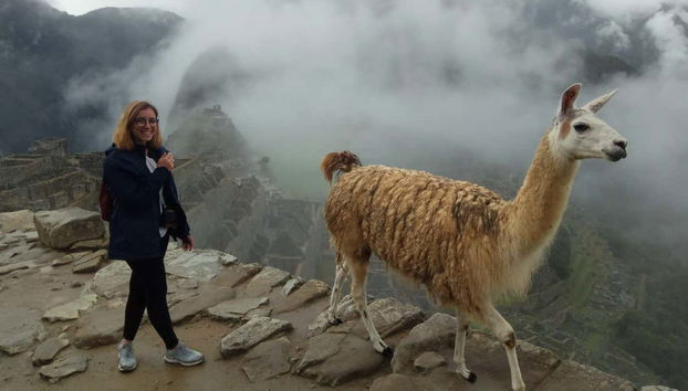 Una turista con una llama en Machu Picchu
