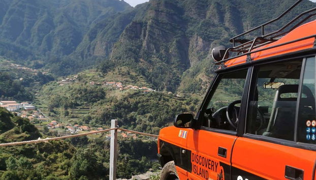 An orange jeep with a view of the mountains
