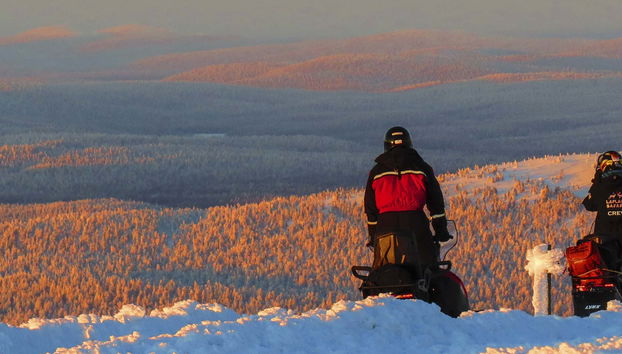 Paseo en moto de nieve bajo la aurora boreal