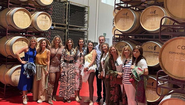 A group photo in front of the winery's barrels
