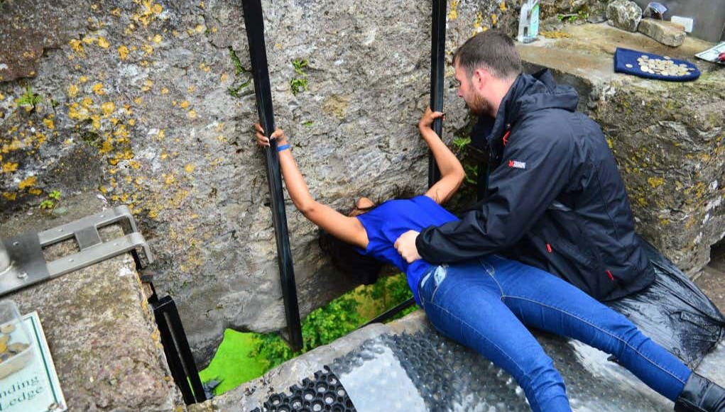 Una ragazza bacia la Pietra di Blarney