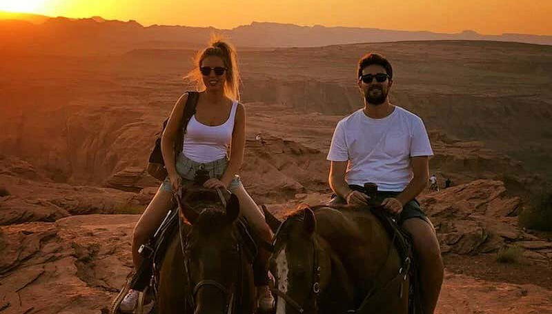 Una coppia a cavallo al tramonto