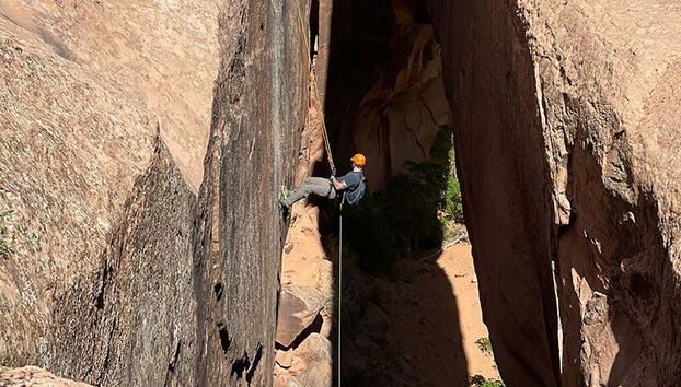 Un garçon faisant du canyoning sur la paroi d'un canyon