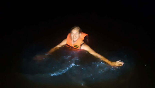 Una donna nuota nelle acque luminescenti