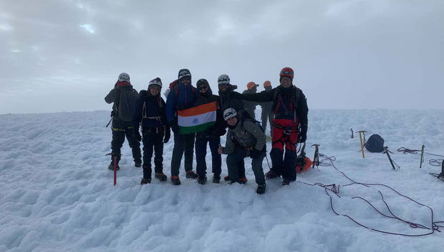 Group photo at the top of the snow-capped mountain