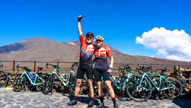 Posando con pose victoriosa junto a las bicicletas