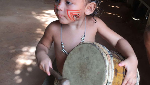 A child playing a traditional drum