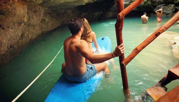 Entrez dans le cénote sur une planche de surf