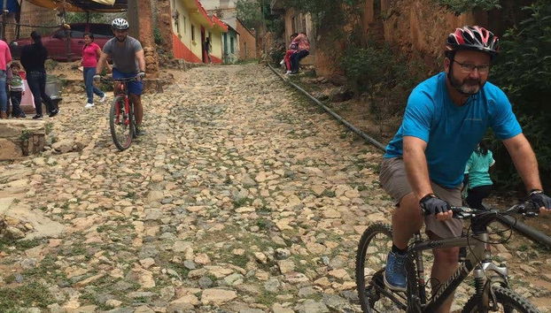 Felices, paseando en bicicleta por calles empedradas
