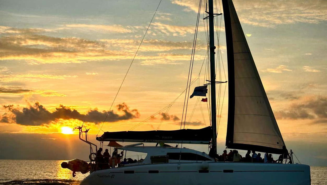 Navegando no catamarã ao pôr do sol