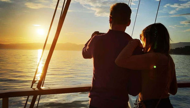 Casal desfrutando do entardecer do barco