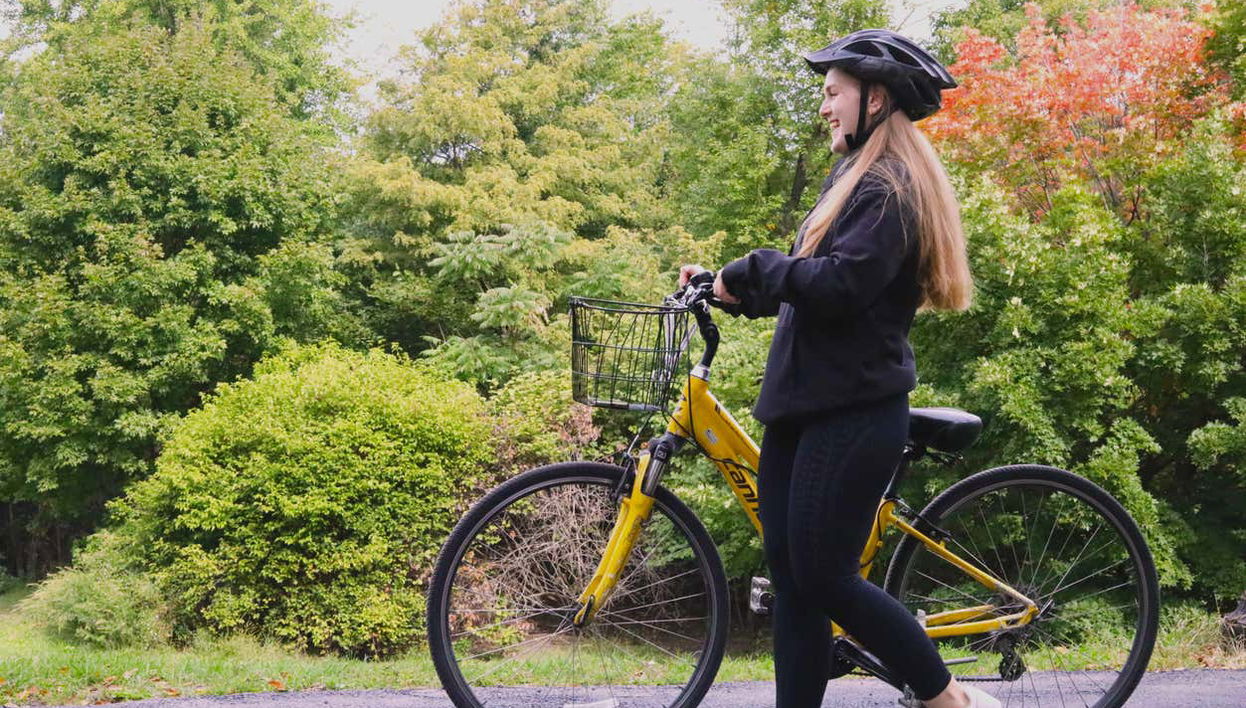 Uma jovem passeando com uma bicicleta