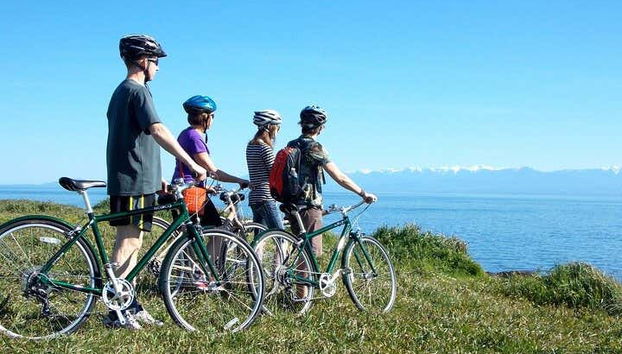 Ciclistas contemplando a costa de Victoria, Canadá
