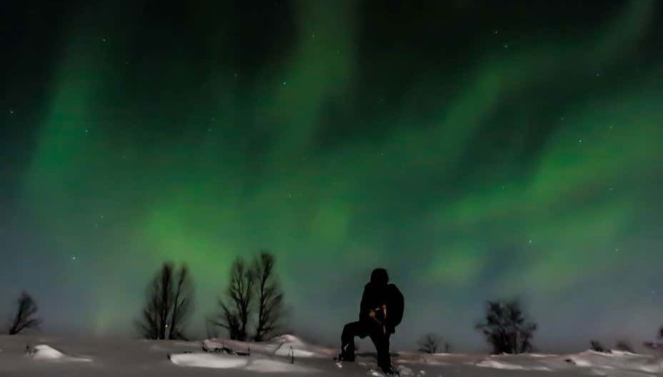 Un turista contempla una magnifica aurora boreale