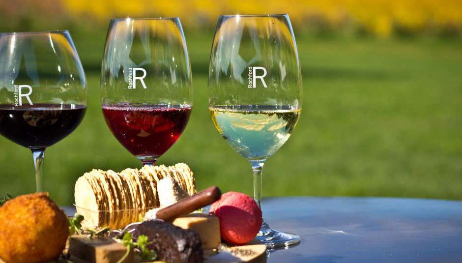 Unas copas de vino con el viñedo de fondo