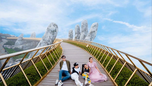 Una famiglia posa sul Ponte Dorato a Da Nang