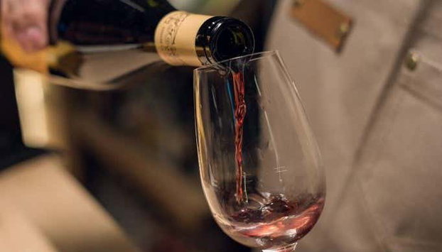 Visita a la vinoteca Wine House - Foto 4, Sirviendo una copa de vino tinto