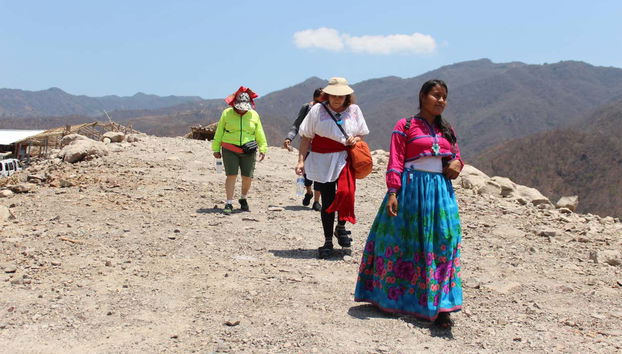 Partecipanti seguono un membro della comunità huichol