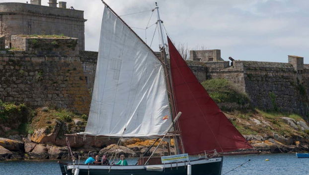 Veleiro passando em frente do Castelo de San Antón