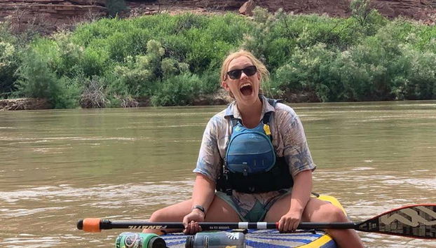 Une fille assise sur une planche de paddle
