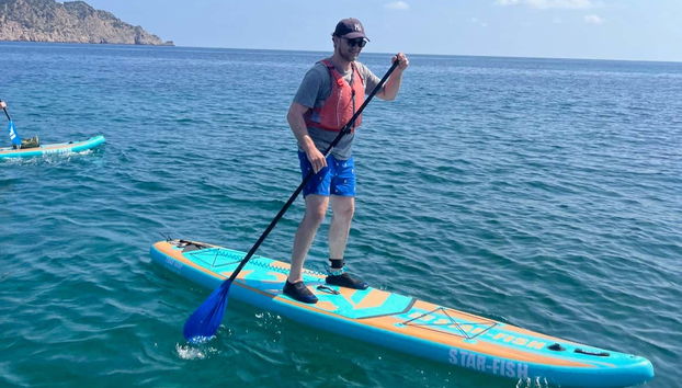 Un ragazzo praticando paddle surf a Ibiza