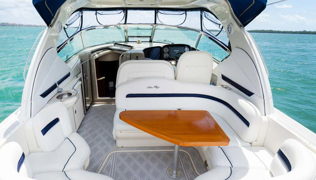 Aluguel de iate em Fort Lauderdale - Foto 4, Convés com assentos brancos e uma mesa de madeira