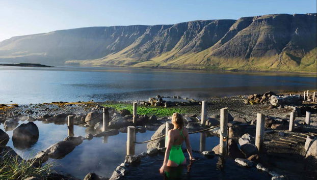 Une femme dans l'une des piscines extérieures de Hvammsvík