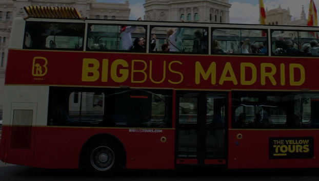 Autobús de Big Bus recorriendo Madrid al caer la tarde