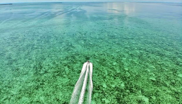Um barco navegando nas águas cristalinas