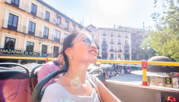 Turista a bordo del autobús descapotable