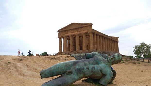 Escultura de ''Icaro caído'' junto a uno de los templos