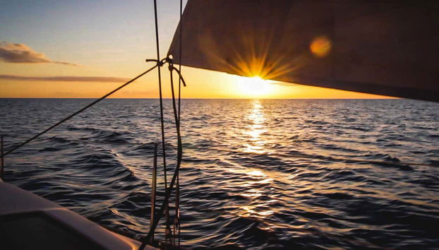 A boat sailing along the calm waters at sunset