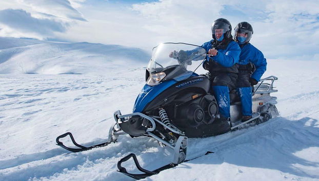 Couple profitant de la balade en motoneige