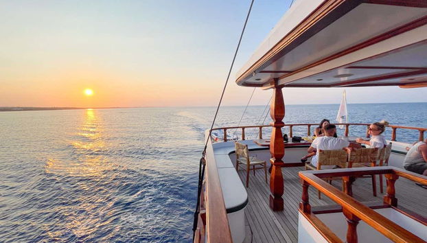 Sentados no convés do barco contemplando o pôr do sol